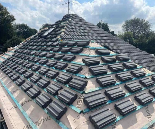 This is a photo of a new hip roof being installed. New felt, battens, and grey tiles have been installed, also a new velux window. Works carried out by LKP Roofing Thorne